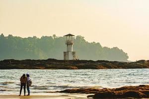 faro luminoso khao lak, bellissimo tramonto sulla spiaggia di nang thong, khao lak, thailandia. tramonto tropicale colorato con cielo nuvoloso. modelli trama di sabbia sulla spiaggia, mare delle Andamane phang nga thailandia foto