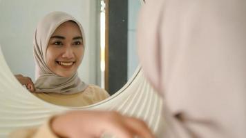 la bella giovane musulmana sorride dolcemente allo specchio foto