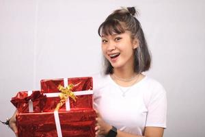 asiatico giovane donna sorridente portare alcune scatole regalo sfondo bianco. foto