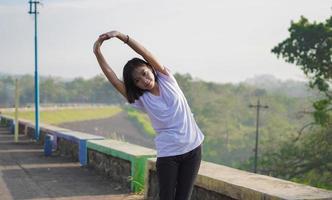 la giovane donna asiatica si è allungata prima di fare jogging e correre al mattino foto