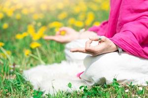 posizione yoga praticalo una ragazza nella natura in fiori primaverili foto