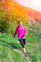 ragazza con un sorriso allegro corre nella natura foto