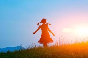 ragazza con le trecce che cammina libera nella natura al tramonto foto