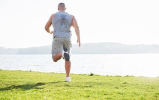 fitness uomo atleta jogging nella natura durante il tramonto. persona che corre allenandosi vivendo uno stile di vita attivo allenamento cardio in estate in abbigliamento sportivo e scarpe. foto