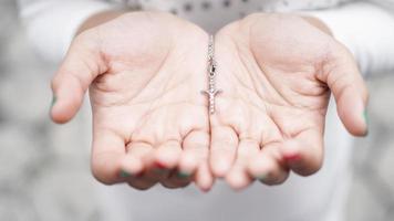 mano di donna con una croce e una Bibbia foto