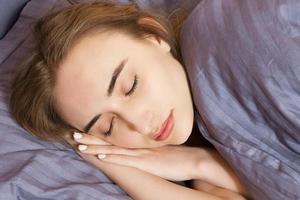 la donna dorme sul letto di notte, un sonno sano, la ragazza dorme in camera da letto. foto