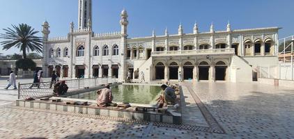 islamabad, punjab, pakistan - 2021, jama masjid golra sharif moschea pittoresca vista mozzafiato con visitatori musulmani che si lavano i piedi e le mani in una giornata di sole foto