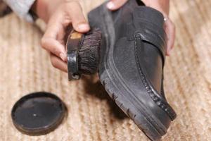 pulire le scarpe con una spazzola sul pavimento foto
