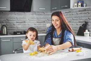 una bellissima figlia con sua madre sforna gli auguri di buon anno. Buon Natale foto