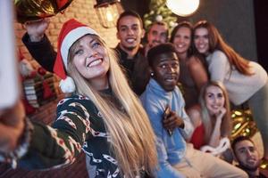 gruppo di amici che festeggiano il nuovo anno al chiuso foto