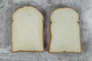 fetta di pane bianco isolata su fondo di legno foto