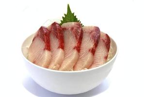 sashimi hamachi affettato, messo su ghiaccio in una ciotola. foto