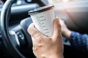 signora asiatica che tiene tazza di caffè caldo cibo da bere in auto, pericoloso e rischia un incidente. foto