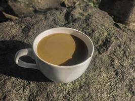 tazza bianca di caffè cremoso isolato su sfondo di pietra foto
