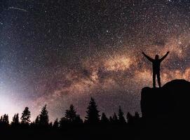 silhouette giovane uomo sfondo della Via Lattea su una stella luminosa tonalità del cielo scuro foto