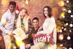 amici multiculturali che riposano insieme a casa la vigilia di Natale foto