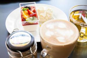 crema di fragole e una tazza di tè e caffè su uno sfondo di legno, fuoco selettivo foto