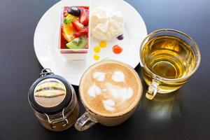 crema di fragole e una tazza di tè e caffè su uno sfondo di legno, fuoco selettivo foto