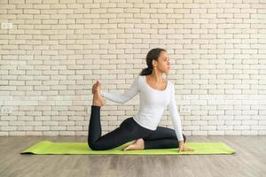 donna latina che pratica yoga su mat foto