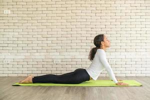 donna latina che pratica yoga su mat foto
