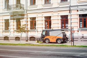 processo di pulizia della città di strada con una moderna macchina per la pulizia foto