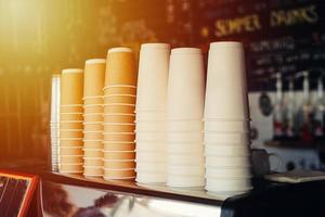 diversi bicchieri di carta per caffè impilati all'interno del bar foto