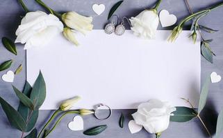 spazio di copia su carta bianca. cornice con fiori. nastro di seta. sfondo grigio. bouquet semplice. biglietto d'auguri. foto