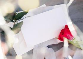 spazio di copia su carta bianca. cornice con fiori. nastro di seta. sfondo grigio. bouquet semplice. biglietto d'auguri. foto