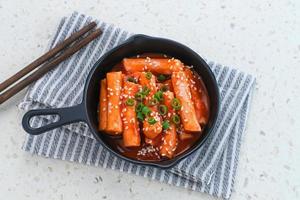 tteokbokki o topokki, bastoncini di torta di riso saltati in padella, popolare street food coreano con salsa gochujang piccante e semi di sesamo. foto