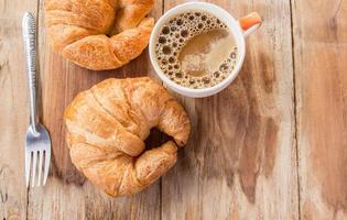 croissant e caffè per colazione sul vecchio tavolo di legno