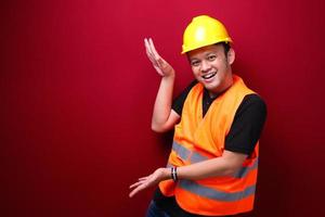 sorriso e felice giovane lavoratore asiatico è con il punto della mano su uno spazio vuoto foto