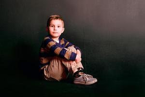 ritratto di un ragazzino carino alla moda in studio fotografico foto