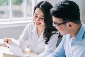 due uomini d'affari asiatici che lavorano in ufficio foto