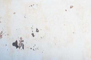parete scheggiata in bianco con macchie di umidità foto