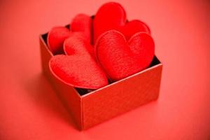 scatola regalo aperta con cuore in scatola rossa sorpresa per regalo per buone vacanze di natale felice anno nuovo o romantico San Valentino su sfondo rosso filantropia donare aiuto dare amore prendersi cura foto