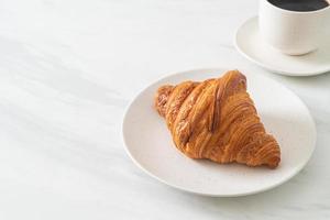 croissant fresco sul piatto bianco foto