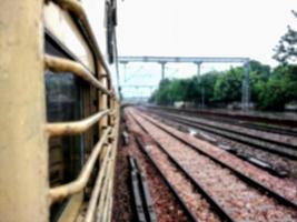 vista offuscata del treno ferroviario indiano in piattaforma, le ferrovie indiane trasportano circa 7.500 milioni di passeggeri all'anno. foto