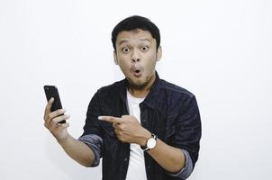 giovane asiatico scioccato quando guarda e indica lo smartphone foto