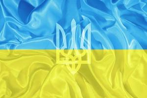 tridente sullo sfondo della bandiera gialla e blu dell'ucraina. simbolo nazionale dello stato dell'ucraina foto