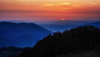 tramonto rosso nel paesaggio di montagna con travi di sole. carpati foto