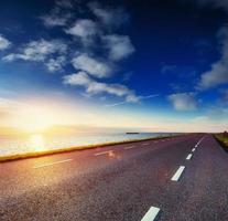 strada asfaltata lungo il mare al tramonto foto