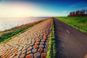 strada asfaltata lungo il mare al tramonto foto