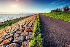 strada asfaltata lungo il mare al tramonto foto