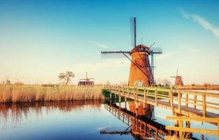 colorata giornata di primavera con il tradizionale canale olandese dei mulini a vento a ro foto