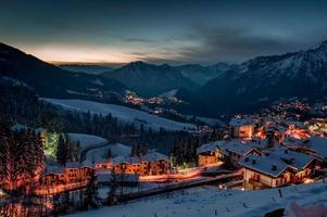 villaggio di montagna coperto di neve alla fine della giornata foto