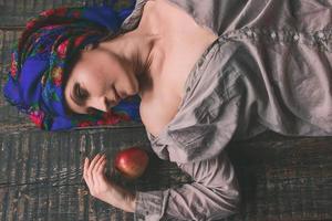donna matura triste in copricapo nazionale ucraino con mela foto