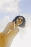 ritratto di donna asiatica sorridente felice con vista cielo blu dal basso. foto