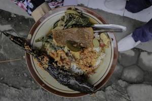 Il pesce gatto piccante mangut è uno dei piatti tradizionali di Yogyakarta a base di pesce gatto affumicato con curry e contorni foto