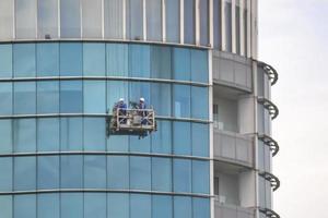 bekasi, west java, indonesia, 5 marzo 2022. i lavoratori del servizio del cielo stanno pulendo le finestre dell'edificio della torre foto