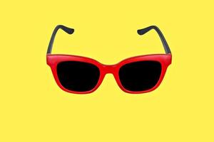 occhiali da sole rossi su sfondo giallo foto
